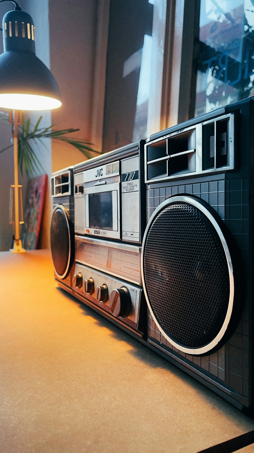 the-story a-radio-sitting-on-top-of-a-table-next-to-a-lamp-yqwbh413o4k